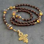 Garnet (12mm) with Murano glass Paters , gold vermeil bead caps, accented with Swarovski crystals, bronze casting of antique Ethiopean cross ($185.00 plus $5.20 S/H)