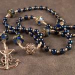 Dark blue fresh water pearls, Murano glass paters, sterling silver spacers, with sterling silver Mariner's cross. $145.00 plus $7.50 S/H.